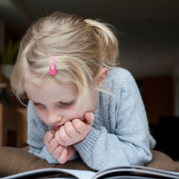 Kind leest geboeid een boek