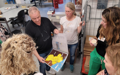 Een medewerker laat tijdens de Kickstartdagen AOB'ers een voorbeeld zien van een voelbare topografiekaart