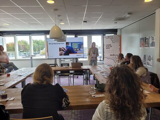 Een medewerker vertelt een groep AOB'ers tijdens de Kickstartdagen over het productieproces bij Dedicon